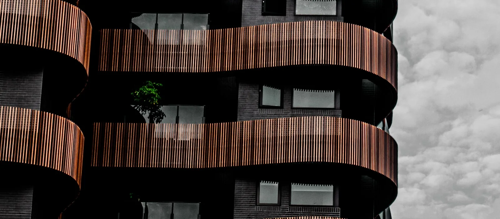 Fachada de un edificio residencial moderno con balcones curvos de madera